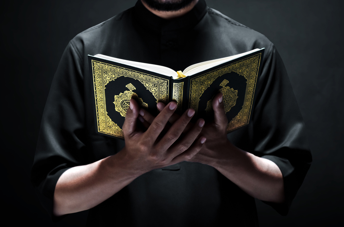 Religious muslim man reading holy quran